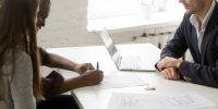 Interracial couple signing mortgage investment contract at meeti Interracial couple signing mortgage investment contract making real estate deal at meeting with broker realtor or financial advisor, happy family clients customers taking bank loan buying new house